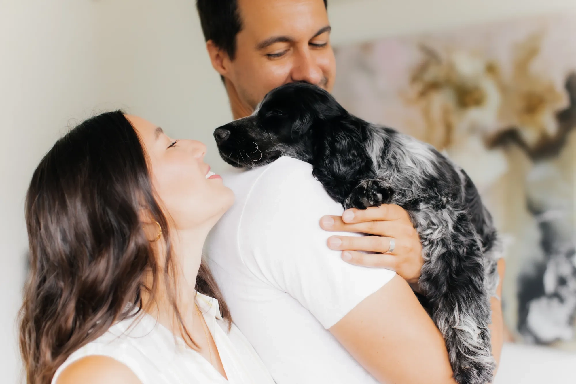 Couple cuddle with their dog during a candid lifestyle family and puppy photoshoot in Melbourne